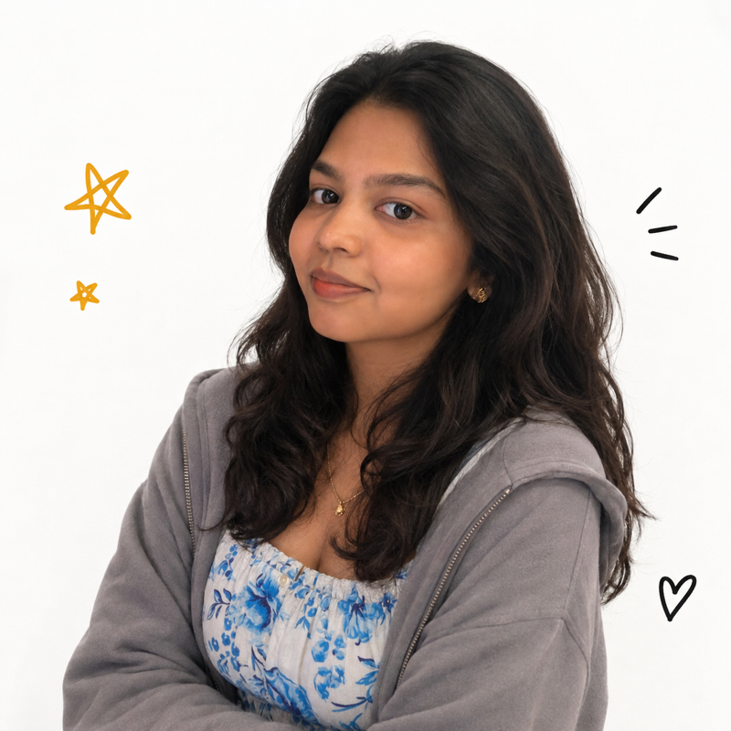 Amutha Varsni Rajkumar, arms crossed, with small hand-drawn stars and a heart added around the photograph